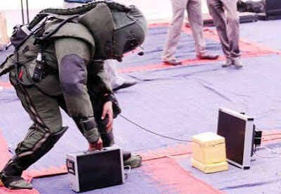 Bomb disposal technician in protective suit